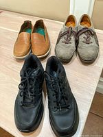 All three pairs of shoes on table