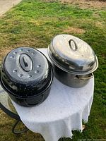 Two oval roasting pans with lids on table