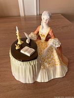 Front view of seated lady figurine at desk