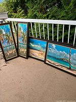 All four framed tropical beach prints leaning against railing