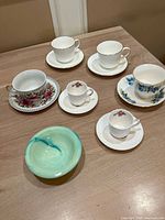 All items laid out: four teacup sets, two espresso cup sets, glass bowl