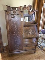 Full front view of side-by-side secretary showing cabinet, drawers, slant desk, mirror and crest