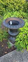 Full view of cast iron urn in garden setting