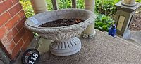 Full view of concrete urn planter on porch step