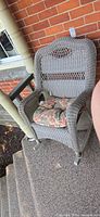 Full view of wicker armchair on porch steps