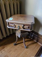 Full view of side table showing drawer front, pedestal, cabriole legs