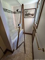 Full side view of wooden A-frame easel beside bathtub