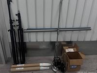 Lot overview showing stands, crossbar, umbrellas in tubes, AlienBees unit and cables