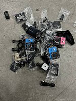 Lot overview showing three action cameras, one dash camera, and assorted mounts