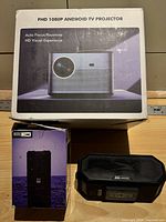 Boxed FHD 1080p Android TV projector, boxed Altec Lansing speaker, loose Altec Lansing speaker