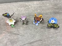 All four Lenox porcelain butterfly-on-flower figurines lined up