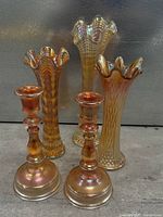 Group shot of three swung vases and two candlesticks showing overall style and color
