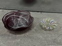 Cranberry red bowl and clear ruffled dish side by side