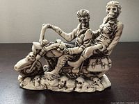 Front left view of resin skeleton riders on motorcycle showing detail of skull base