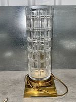 Full view of crystal column lamp on brass base with cord