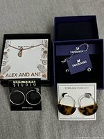 Overall view of all four jewelry pieces in their boxes/cards