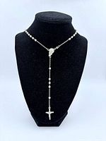 Rosary displayed on bust showing drop and crucifix