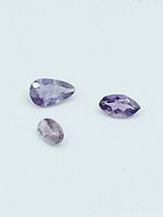 Three faceted amethyst gemstones on white background
