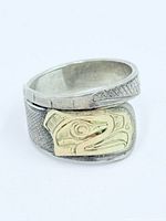 Front view showing gold eagle overlay and silver band texture