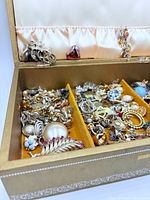Open jewelry box showing compartments filled with assorted jewelry items