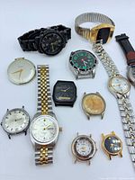 All twelve wristwatches laid out showing variety of styles and conditions