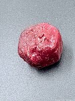 Top view of rough ruby showing color and surface texture
