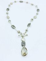 Full view of the necklace laid flat showing bead arrangement and pendant