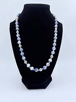 Necklace on black bust displaying front view of beads and spacers