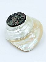 Top view showing carved palm tree insert and iridescent shell body