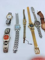 All eight watches laid out left to right showing faces and bands