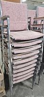 Stack of ten matching upholstered metal-frame armchairs