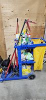 Overall view of blue janitorial cart and all visible cleaning supplies