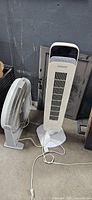 Front view of Noma tower fan and tabletop box fan showing overall condition and cords