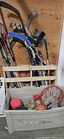 Lot overview showing hockey sticks, tote with balls and rim