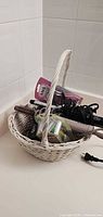 Basket showing hair dryer, curling irons, brush and both razor packs