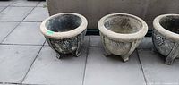Both concrete planters side by side showing shape, relief and feet