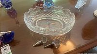 Cut crystal oval bowl and two glass-topped wine stoppers on table
