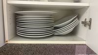 Stack of dinner plates and pasta bowls in cabinet