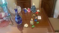 All items on tabletop including crystal decanter, Murano bottle, rooster figurine, floral decor
