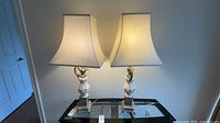 Both table lamps with shades on glass table