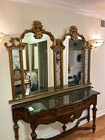 Front view of full mirror on wall showing four panels and carved crest