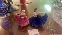 Both Royal Doulton figurines side by side on table