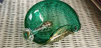 Top view of green art glass ashtray showing curled rim, gold flecks, controlled bubbles