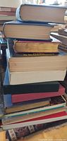 Stack of roughly twelve books varied sizes