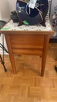 Full view of wood side table front and tile top