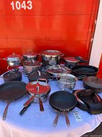 Full lot overview showing variety of pots, pans, lids