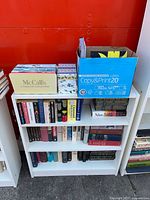 Front view of bookcase with McCall's slipcase, box of books, and two shelves of assorted books