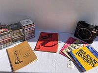 Full lot view with CDs stacked, radio, books, notebook