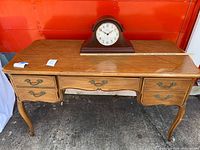 Full view of Thomasville desk with four drawers, cabriole legs, Howard Miller mantel clock on top
