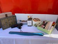 Overview showing hardware organizer, Craftsman screwdriver, decorative tins, brushes, long metal bar and tan case